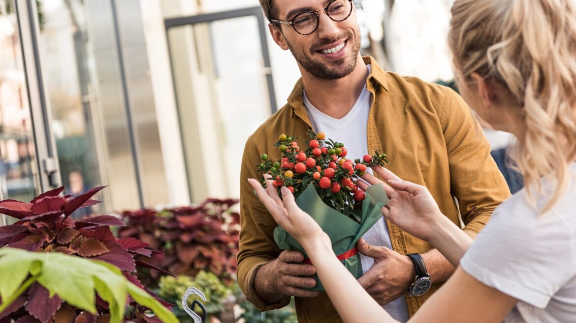Smiling couple with flowers at a market, flowers theme